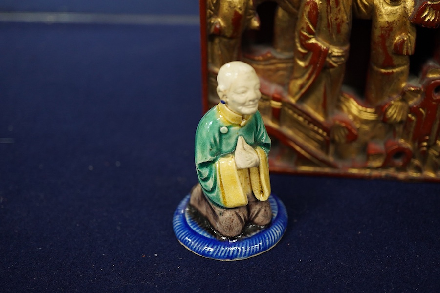 A Chinese carved and giltwood panel, sancai figure and carved coquilla nut, largest 21 x 14.5cm